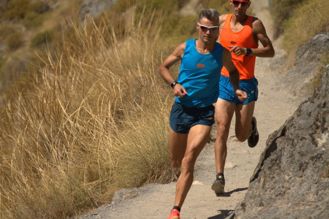 2 runners, running swiftly on the trails